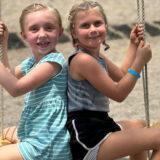 Two girls on swing together